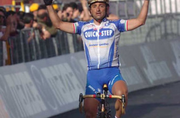 Paolo Bettini takes the win ahead of the hungry sprinters. Photo copyright Fotoreporter Sirotti.