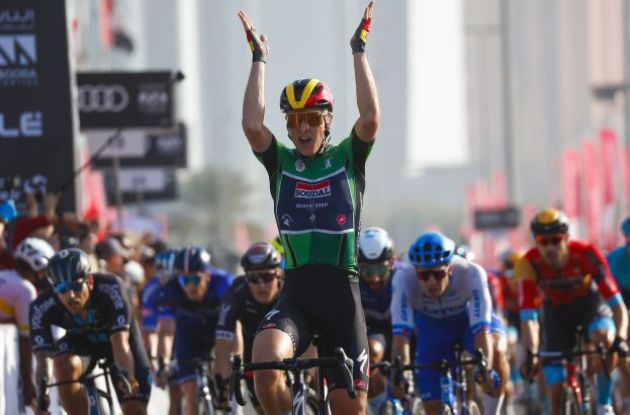 Tim Merlier raises arms above head after winning stage 6 of UAE Tour 2023