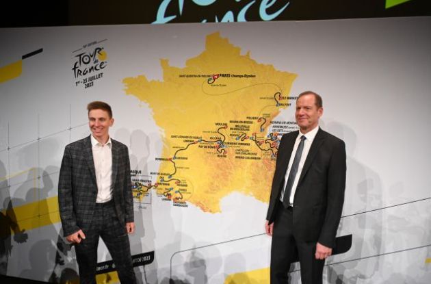 Tadej Pogacar and Christian Prudhomme smiling in front of 2023 Tour de France map