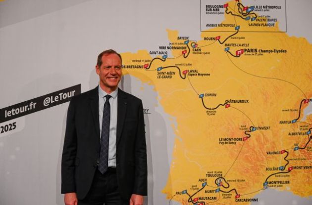 Christian Prudhomme next to the map of Tour de France 2025