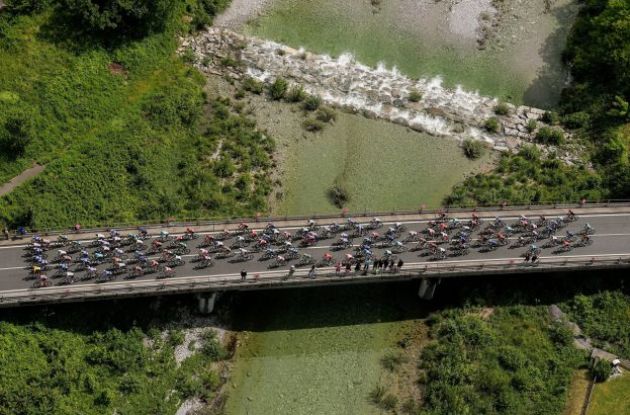 Cycling peloton crosses a bridge