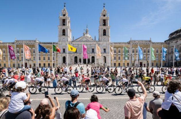 La Vuelta cyclists riding past famous Sevilla architecture