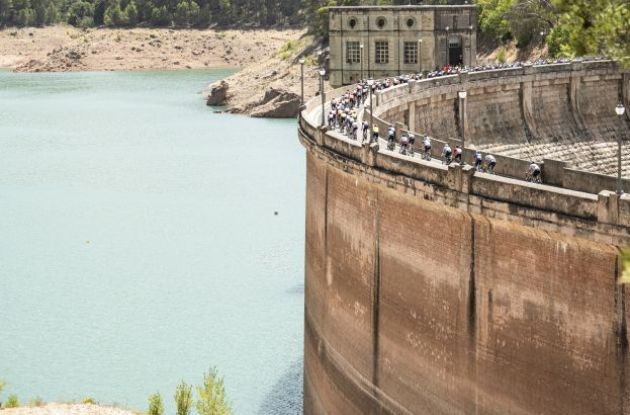 La Vuelta cyclists passing historic dam