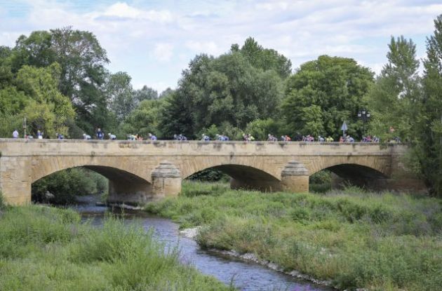 Cyclists on historic bridge in Rioja