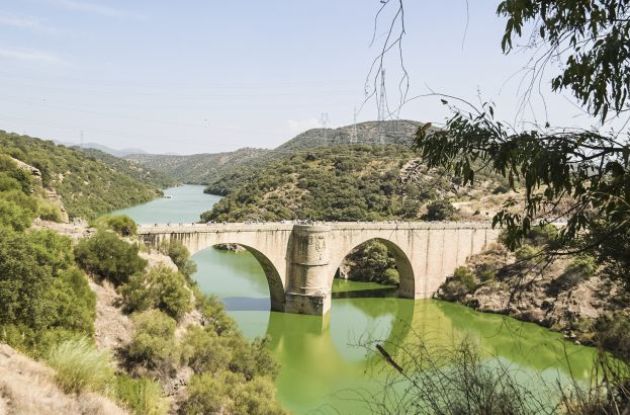 Cyclists crossing historic bridge