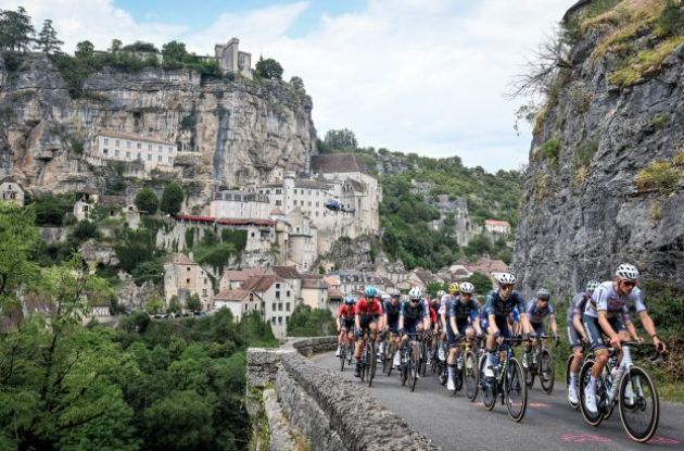 Tour de France peloton riding past mountain town in France