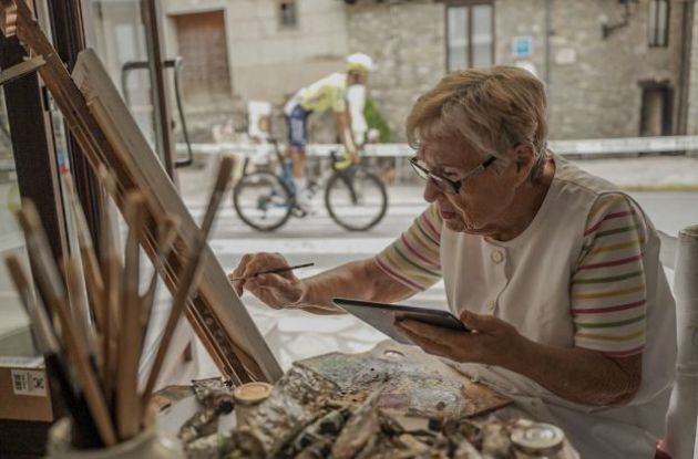 Artist painting while Vuelta a Espana cyclist rides by