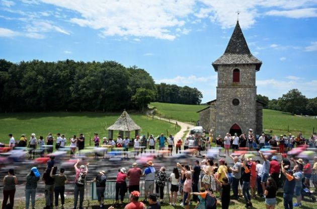 Cyclists passing French village church