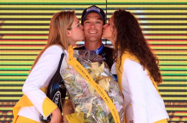 David Millar celebrates his powerful stage win on the podium with the podium girls. Photo Fotoreporter Sirotti.
