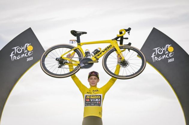 Jonas Vingegaard lifting his Cervelo bike on the Tour de France podium in Paris