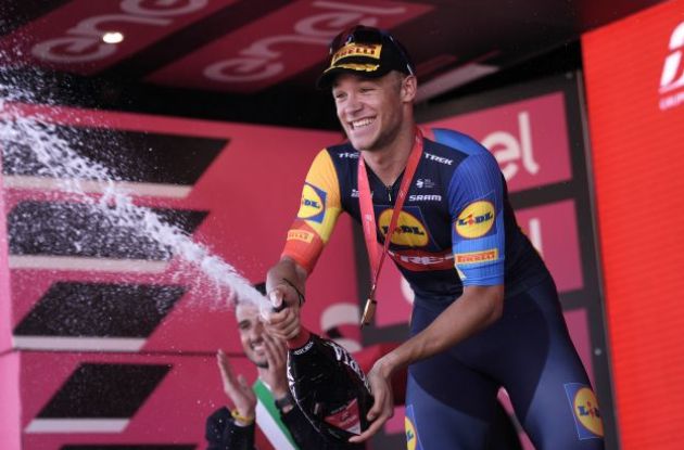 Jonathan Milan celebrates with champagne on the podium