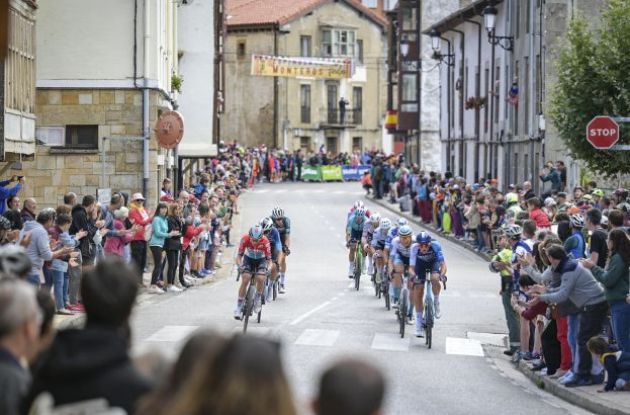 Professional cyclists riding through spanish village