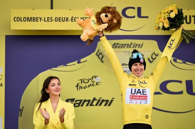 Tadej Pogacar wearing the yellow jersey on the Tour de France podium