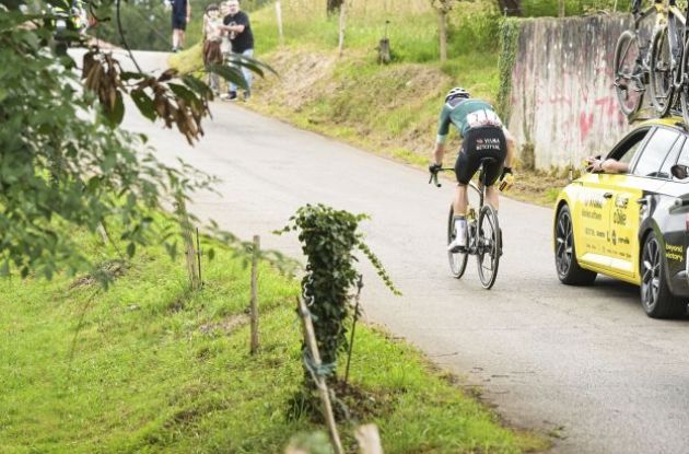 Wout van Aert with his team car following crash in stage 16 of Vuelta a Espana