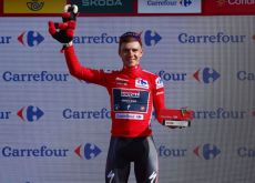 Remco Evenepoel on the podium wearing the Vuelta a Espana leader jersey