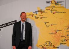 Christian Prudhomme next to the map of Tour de France 2025