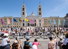 La Vuelta cyclists riding past famous Sevilla architecture