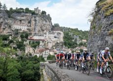 Tour de France peloton riding past mountain town in France