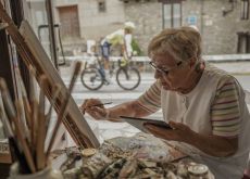 Artist painting while Vuelta a Espana cyclist rides by