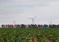Paris-Nice peloton passing by wind turbines in central France
