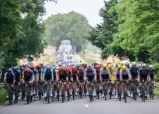 Cyclists riding through forest during stage 10 of Tour de France 2024