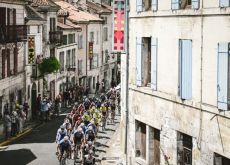 Cyclists ride through French village