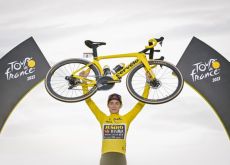 Jonas Vingegaard lifting his Cervelo bike on the Tour de France podium in Paris
