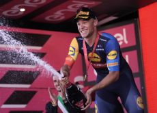 Jonathan Milan celebrates with champagne on the podium