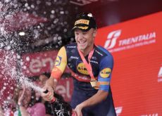 Jonathan Milan celebrates with champagne on the podium