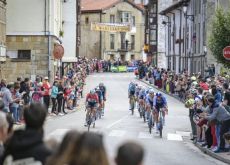 Professional cyclists riding through spanish village