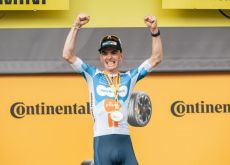 Romain Bardet waving on the Tour de France podium after winning stage 1
