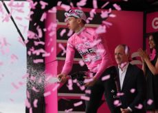 Tadej Pogacar celebrating his Giro d'Italia lead with champagne on the podium