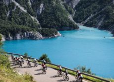 Cyclists pass by mountain lake