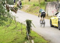 Wout van Aert with his team car following crash in stage 16 of Vuelta a Espana