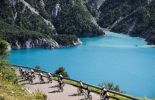 Cyclists pass by mountain lake