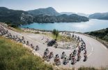 Tour de France cyclists in French Alps with mountain lake